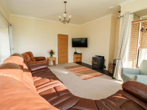 a living room with a couch and a flat screen tv at Bicton Lea in Acton