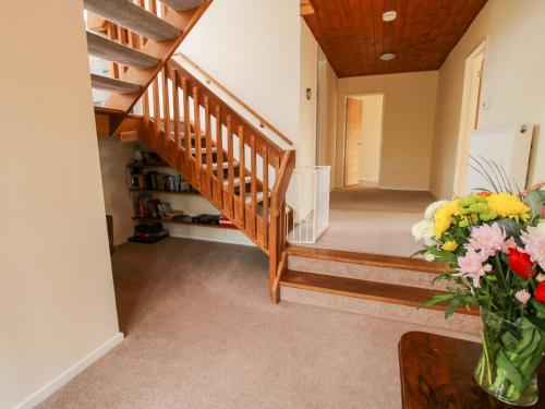 a hallway with stairs and a vase of flowers at Bicton Lea in Acton