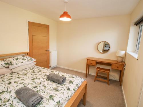 a bedroom with a bed and a table and a mirror at Bicton Lea in Acton