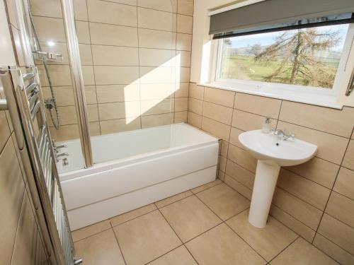 a bathroom with a sink and a bath tub and a toilet at Bicton Lea in Acton