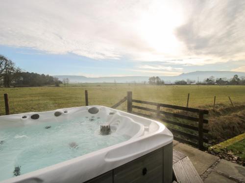 a bath tub with a view of a field at Bicton Lea in Acton