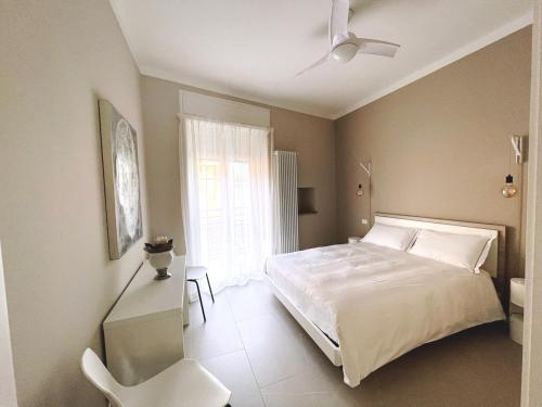 um quarto com uma cama branca e uma cadeira branca em Ca'Sazen Bilo 18 em Brescia