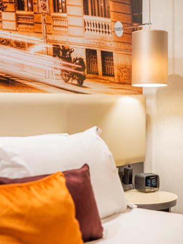 a bedroom with a bed and a clock on a table at Hotel Indigo Madrid - Gran Vía by IHG in Madrid