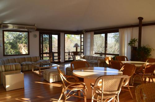 a living room with tables and chairs and windows at Rincon del Este Resort in Punta del Este