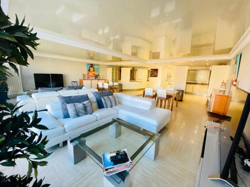 un salon avec un canapé blanc et une table dans l'établissement ''Le cadre royal'' appartement de standing sur quai avec parking, à Sète