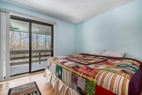 a bedroom with a bed and a large window at Hideaway Valley Condo 36 in Harbor Springs