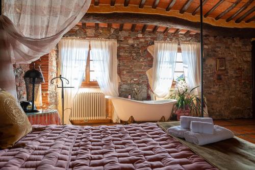 een slaapkamer met een groot bed en een bad bij Luxury Corte Di Re Artù in Lucca