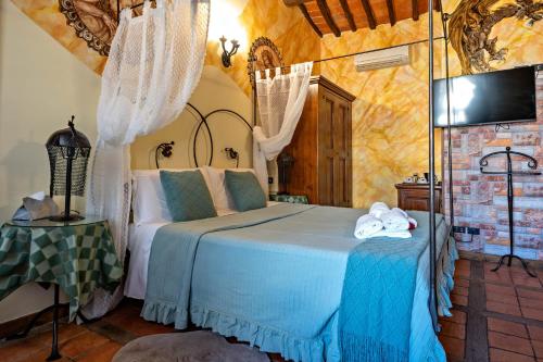 a bedroom with a bed and a tv in a room at Luxury Corte Di Re Artù in Lucca