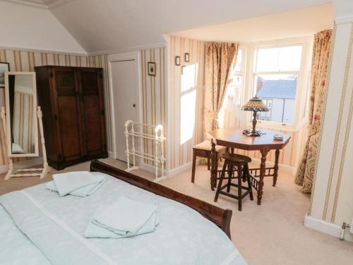 een slaapkamer met een bed, een tafel en een raam bij Iona 10 Palace Street East in Berwick-Upon-Tweed