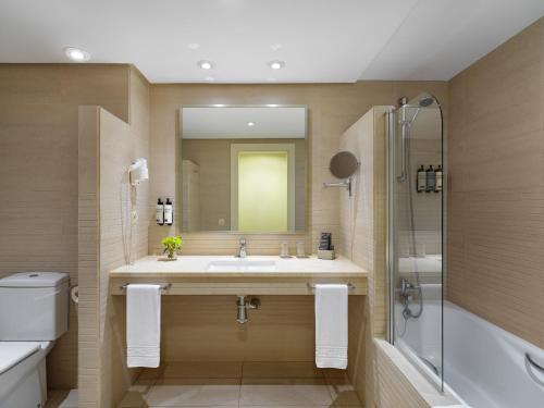 a bathroom with a sink and a shower and a mirror at H10 Estepona Palace in Estepona