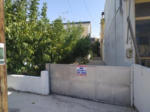 a sign on a fence in front of a building at Chrismma 1-Bed Apt with Private Yard & Parking in Pírgos