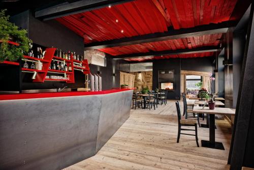 a restaurant with a red bar with tables and chairs at Antico Albergo Stella d'Italia in Folgaria