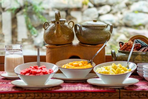 a table with bowls of fruit and a teapot at Del Pilar Ollantaytambo in Ollantaytambo