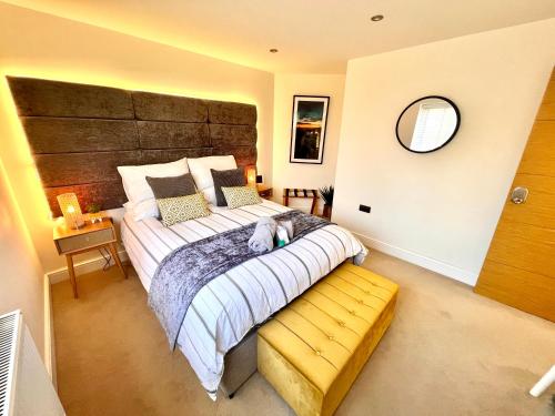 a bedroom with a large bed with a dog laying on it at The Duplex Margate with Deck, Mini Bar & Air Conditioning in Margate