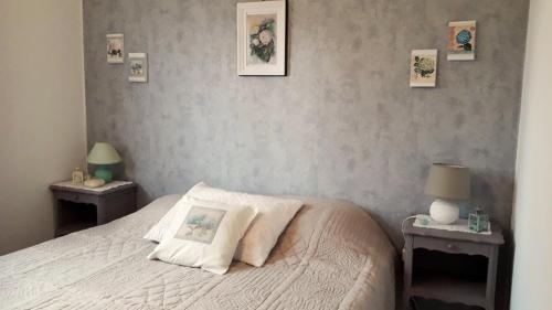 a bedroom with a white bed with two night tables at Gîte Le bel Epi in Vany