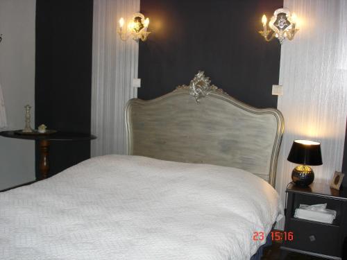 a bedroom with a white bed and black walls at Logis Hôtel DOMAINE du MOULIN in Saint-Avold