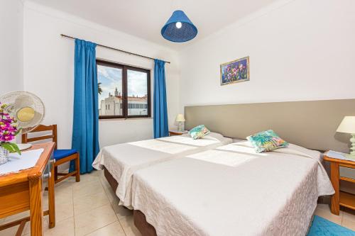 a bedroom with two beds and a window at Apartamentos Carruna in Albufeira