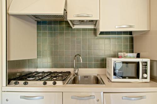 a kitchen with a stove and a microwave at Appartamento Boboba in Marina di Pisa