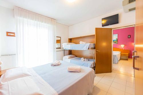 una camera d'albergo con due letti e una finestra di Hotel Arlino a Rimini