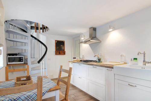 a kitchen with white cabinets and a sink and a table at Stone House of the year 1500 in Moltrasio