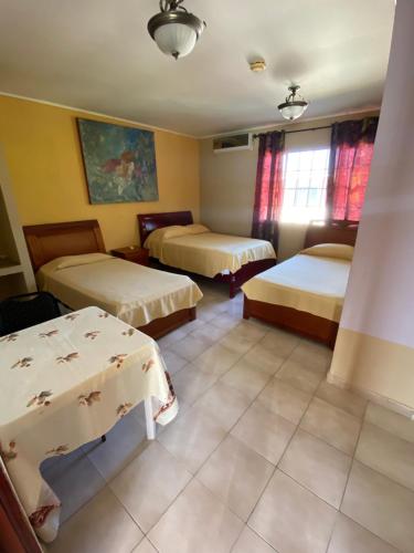 パナマシティにあるCanal Inn B&B Panamaのベッド2台とテーブルが備わるホテルルームです。