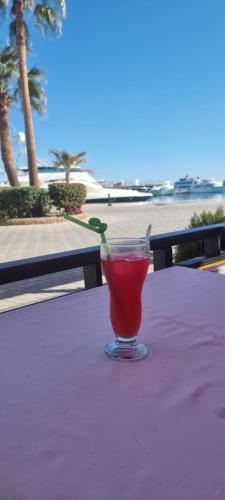 a drink in a glass sitting on a table near the beach at New Marina Appartement Susi in Hurghada
