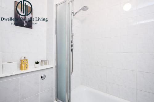 a shower with a glass door in a bathroom at Dwellers Delight Living Ltd Serviced accommodation 2 Bed House, free Wifi & Parking, Prime Location London, Woodford in Woodford Green