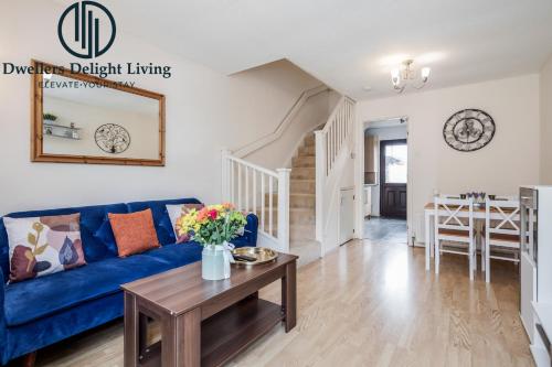 a living room with a blue couch and a table at Dwellers Delight Living Ltd Serviced accommodation 2 Bed House, free Wifi & Parking, Prime Location London, Woodford in Woodford Green