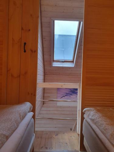 a small room with two beds and a window at Domki Primore in Władysławowo