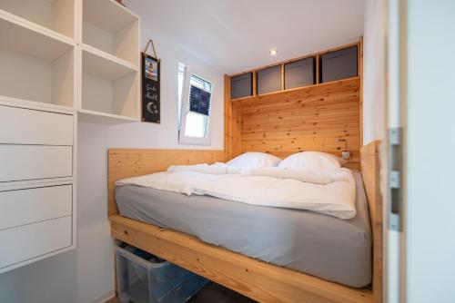 a bedroom with a bed with a wooden headboard at Hafenresort Karnin Hausboot Glaukos in Karnin