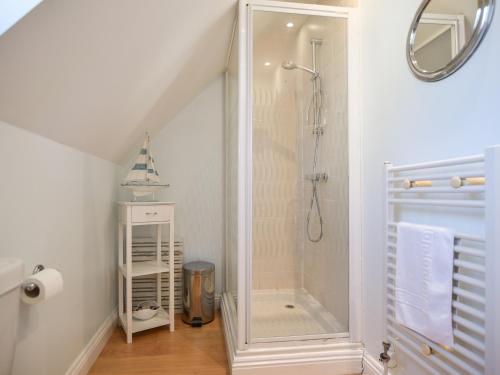 a bathroom with a shower in the corner of a room at Admirals View in Lyme Regis