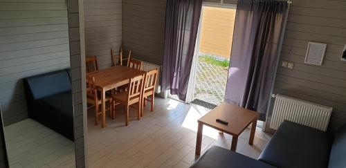 a dining room with a table and chairs in a house at Domki Primore in Władysławowo