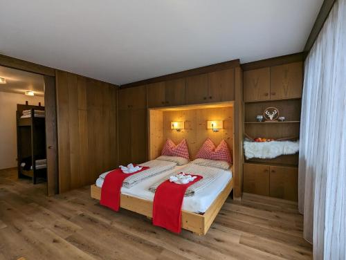 a bedroom with a large bed with two red blankets at Residence Pfeifhofer in Campo Tures