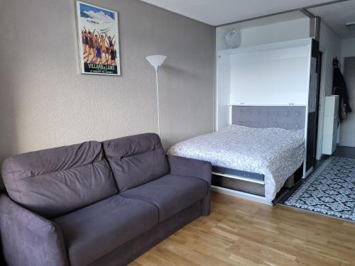 uma sala de estar com um sofá e uma cama em STUDIO plein sud "Les Arolles" Balcon de VILLARD DE LANS em Villard-de-Lans