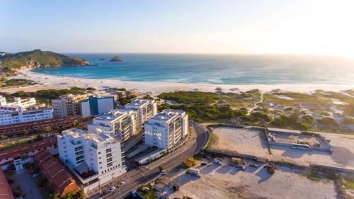 una vista aérea de una playa con edificios y el océano en lindo apartamento de 1 quarto com vista para o mar, en Arraial do Cabo