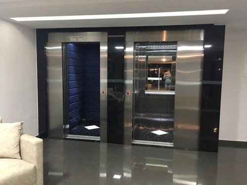 un vestíbulo con dos ascensores en un edificio en lindo apartamento de 1 quarto com vista para o mar, en Arraial do Cabo