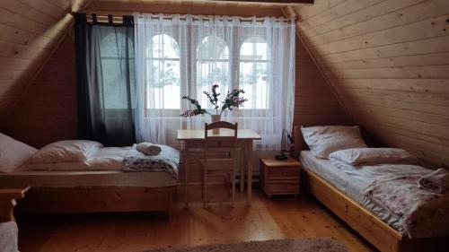 a bedroom with two beds and a window at Chata w chmurach in Gliczarów