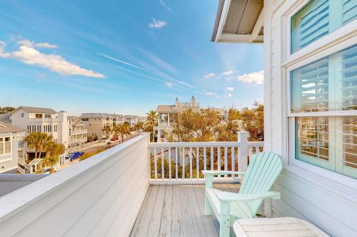 a balcony with a blue chair and a view of the city at True Knot Cottage in Saint Simons Island