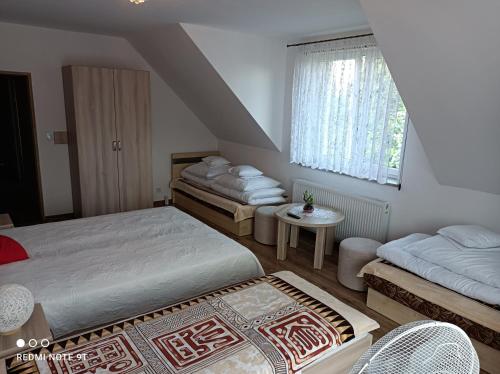 a bedroom with two beds and a window at Apartament Gajówka z ogrodem na wyłączność, Energylandia 35min in Rzyki