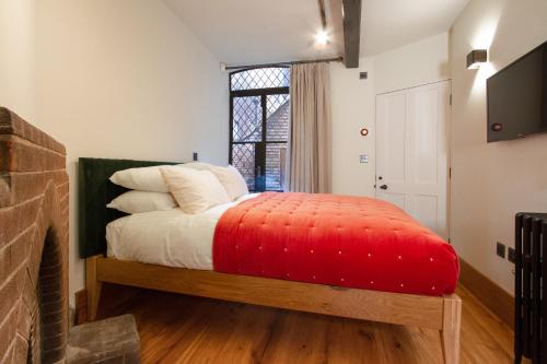 a bedroom with a bed with a red blanket at Coventry Historic Houses in Coventry