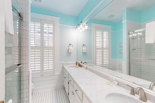 uma casa de banho com 2 lavatórios e um espelho grande em True Knot Cottage em Saint Simons Island