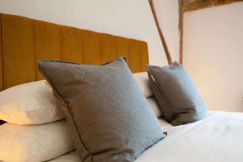 a bed with pillows on top of it at Coventry Historic Houses in Coventry