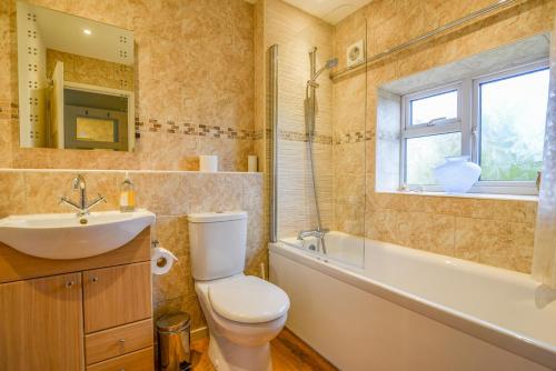 a bathroom with a toilet and a sink and a window at Hove To in Lyme Regis
