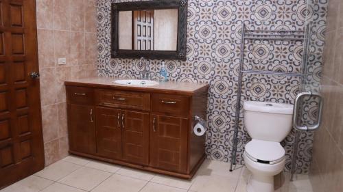 uma casa de banho com um WC, um lavatório e um espelho. em Hacienda Bella em Cabo San Lucas