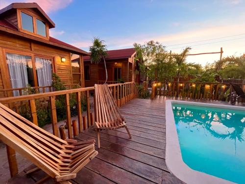 eine Terrasse mit 2 Stühlen und einem Pool in der Unterkunft Anicca Aldea in Holbox