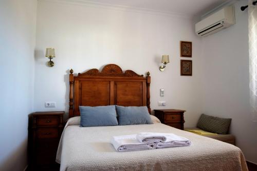 1 dormitorio con 1 cama con 2 toallas en La Casona del Bullaque en El Robledo