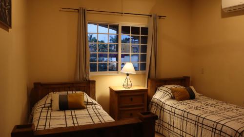 um quarto com 2 camas individuais e uma janela em Hacienda Bella em Cabo San Lucas