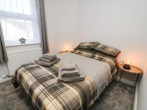 a bedroom with a bed with two towels on it at Myrtle Cottage in Preston