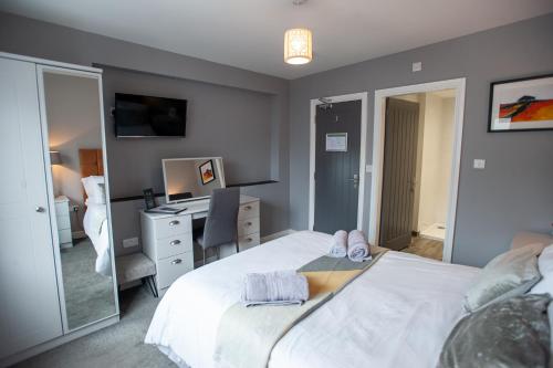a bedroom with two beds and a desk and a mirror at The Slate in Bangor