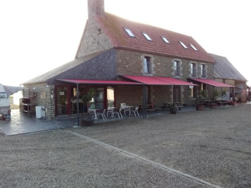 un bâtiment avec des tables et des chaises à l'extérieur dans l'établissement Le Marquis De La Guintre, à Courtils